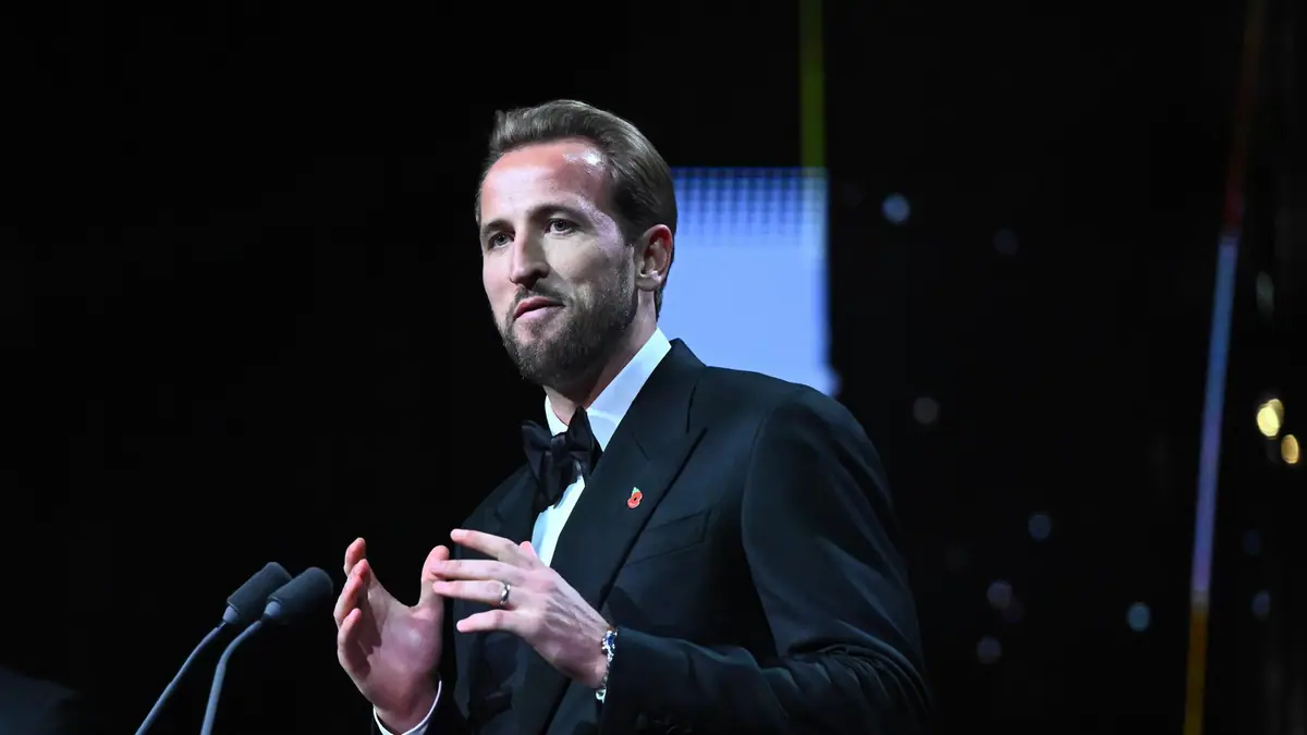Harry Kane in a black tuxedo and bow tie speaking at a podium during the 2026 Ballon d'Or ceremony