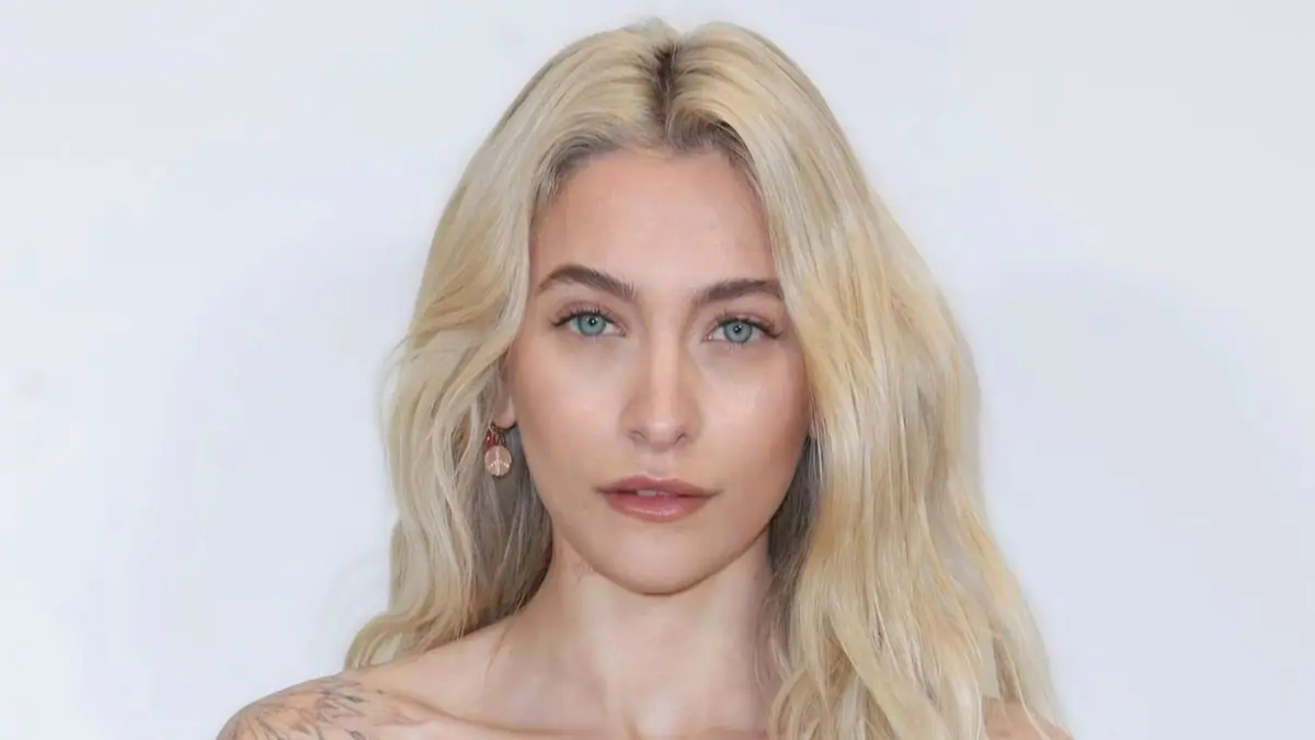 Portrait of Paris Jackson with long blonde hair against a pale background