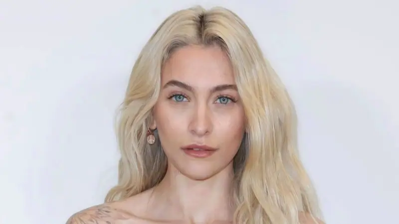 Portrait of Paris Jackson with long blonde hair against a pale background