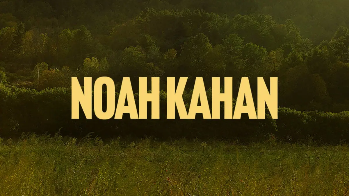 Noah Kahan's name in yellow block letters over a green hillside at sunset, from his official tour page