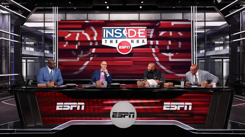 The Inside the NBA studio set on ESPN, with Ernie Johnson seated at the desk beside Shaquille O'Neal, Kenny Smith and Charles Barkley