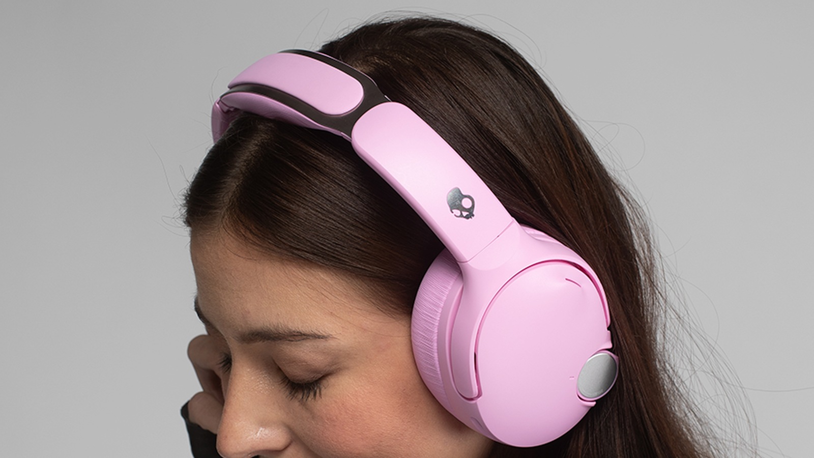 A person wearing pink Skullcandy Crusher 1080 ANC over-ear headphones