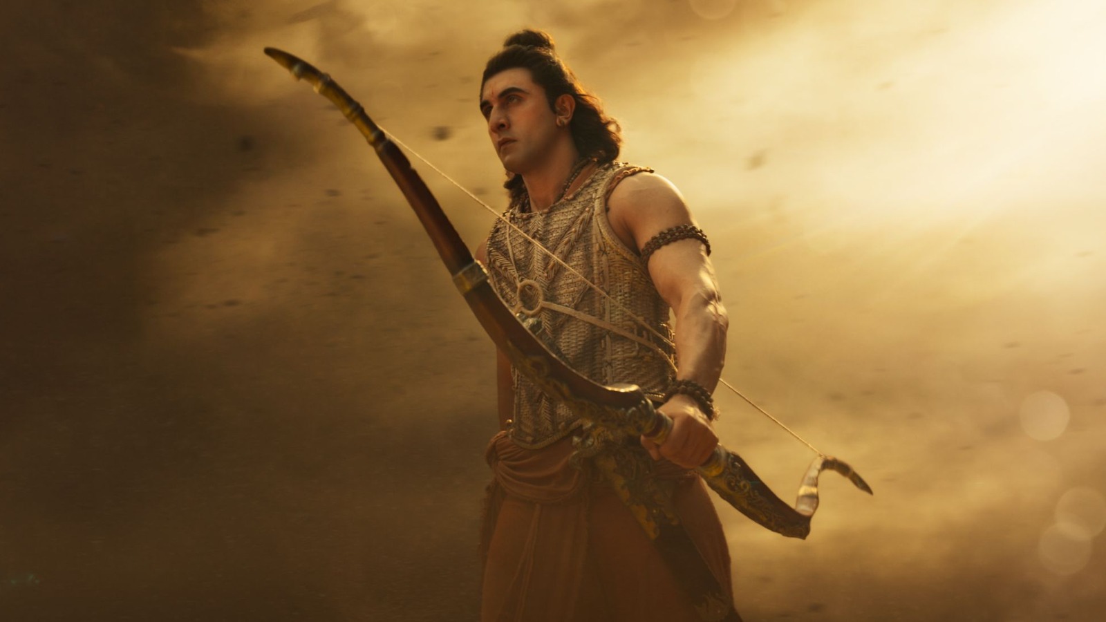Ranbir Kapoor as Rama holding a bow against a dusty golden sky in a still from Ramayana: Part One